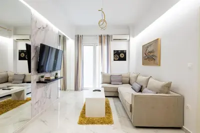 a living room with a couch and a tv at Artistic Stay in the Heart of Athens in Athens