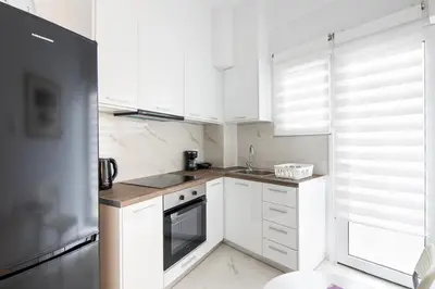 a white kitchen with white cabinets and a sink at Artistic Stay in the Heart of Athens in Athens