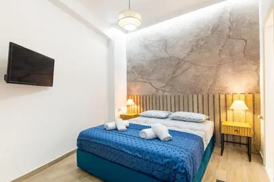 a bedroom with a blue bed with white pillows at Artistic Stay in the Heart of Athens in Athens