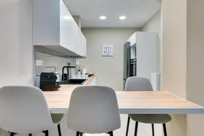 a kitchen with a wooden table and four chairs at Amazing house close to sea in Athens
