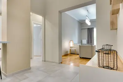 a living room with white walls and a hallway at Amazing house close to sea in Athens