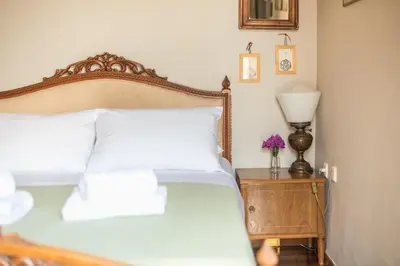 a bedroom with a bed with white pillows and a lamp at Charming Vintage Retreat in Athens