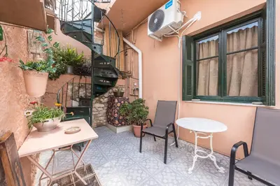 a small patio with a table and chairs on a building at Charming Vintage Retreat in Athens