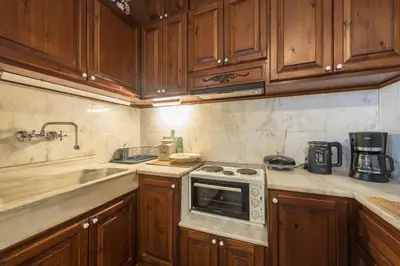 a kitchen with wooden cabinets and a stove top oven at Charming Vintage Retreat in Athens