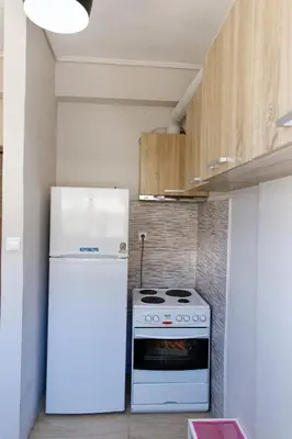 a kitchen with a white refrigerator and a stove at Sunny Penthouse For balcony lovers in Athens