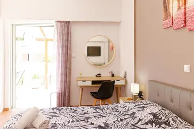 a bedroom with a bed and a desk and a mirror at Sunny Penthouse For balcony lovers in Athens