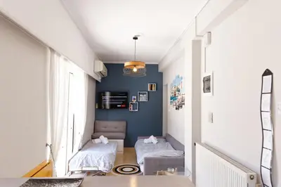 a living room with blue walls and a couch at Sunny Penthouse For balcony lovers in Athens