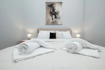 a bedroom with a white bed with towels on it at FilOikos Syntagma Spacious Suite 5Br 2,5Ba in Athens