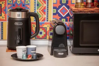 a coffee maker and cups on a counter next to a microwave at FilOikos Syntagma Spacious Suite 5Br 2,5Ba in Athens