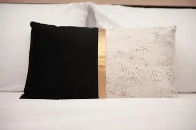 a black and gold pillow sitting on top of a bed at FilOikos Syntagma Spacious Suite 5Br 2,5Ba in Athens