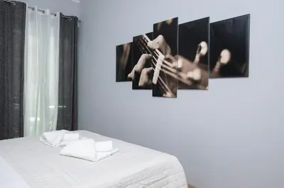 a bedroom with a bed with four pictures on the wall at FilOikos Syntagma Spacious Suite 5Br 2,5Ba in Athens
