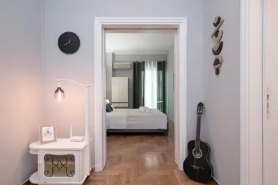a hallway with a bedroom with a bed and a guitar at FilOikos Syntagma Spacious Suite 5Br 2,5Ba in Athens