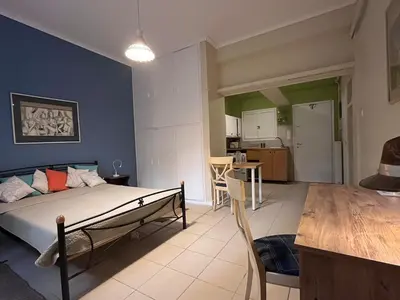 a living room with a bed and a kitchen at Quiet Little Studio in Kolonaki in Athens
