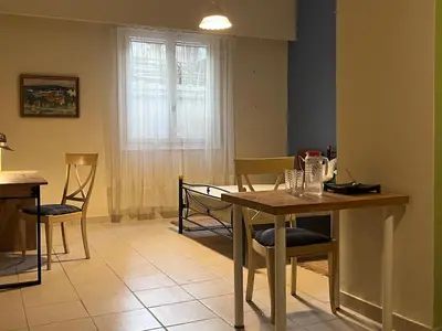 a dining room with a table and chairs and a window at Quiet Little Studio in Kolonaki in Athens