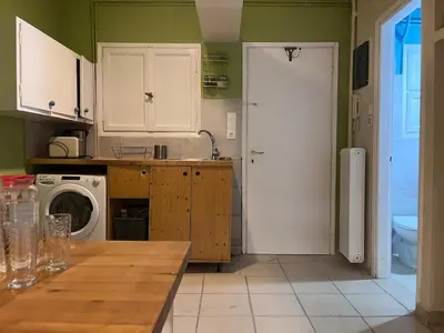 a kitchen with green walls and a white refrigerator at Quiet Little Studio in Kolonaki in Athens