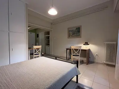 a bedroom with a bed and a table and chairs at Quiet Little Studio in Kolonaki in Athens