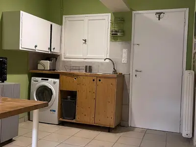a kitchen with a washing machine and a white door at Quiet Little Studio in Kolonaki in Athens