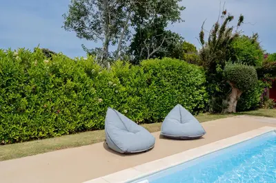 two blue pillows sitting next to a swimming pool at Villa Hyacinth by A&D Properties in Porto Rafti