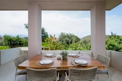 a dining room with a wooden table and chairs at Villa Hyacinth by A&D Properties in Porto Rafti