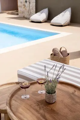 a table with two wine glasses on it next to a pool at Villa Hyacinth by A&D Properties in Porto Rafti
