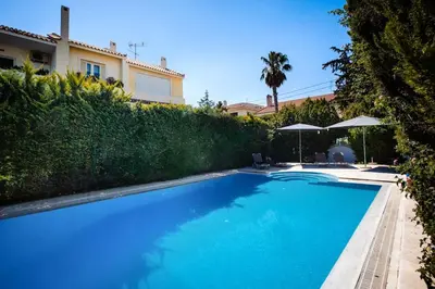 a swimming pool in front of a house at South Blue Tranquil Villa in Athens