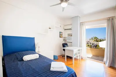 a bedroom with a blue bed and a desk at South Blue Tranquil Villa in Athens