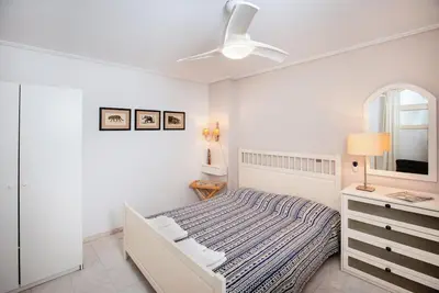 a white bedroom with a bed and a mirror at South Blue Tranquil Villa in Athens