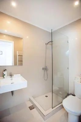 a bathroom with a shower and a sink and a toilet at South Blue Tranquil Villa in Athens