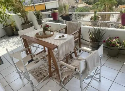 a table and chairs on a balcony with plants at Luxury apt in Pagkrati in Athens