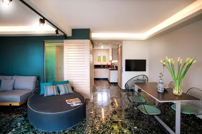 a living room with a couch and a table at Vouliagmeni Kavouri Beachfront Apartment in Athens