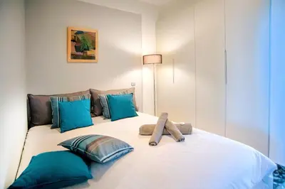 a bedroom with a bed with blue pillows at Vouliagmeni Kavouri Beachfront Apartment in Athens