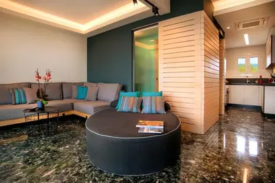 a living room with a couch and a table at Vouliagmeni Kavouri Beachfront Apartment in Athens