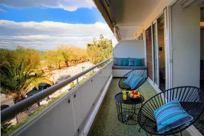 a balcony with two chairs and a table at Vouliagmeni Kavouri Beachfront Apartment in Athens