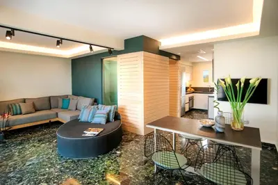 a living room with a couch and a table at Vouliagmeni Kavouri Beachfront Apartment in Athens