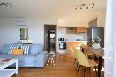 a living room and kitchen with a couch and a table at Saronida Seaside Serenity in Saronida