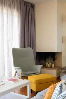 a living room with a chair and a couch at Saronida Seaside Serenity in Saronida