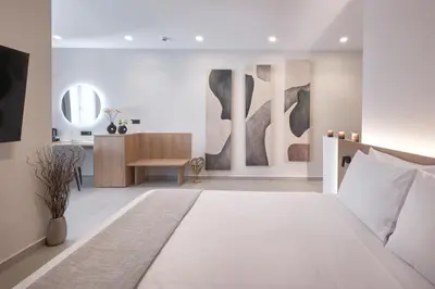 a bedroom with a large white bed and a desk at Athens City Suites in Athens
