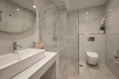 a white bathroom with a sink and a toilet at Athens City Suites in Athens