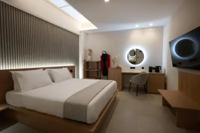 a bedroom with a bed and a desk and a television at Athens City Suites in Athens