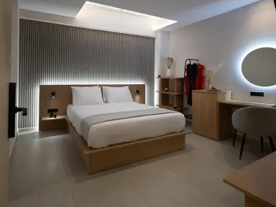 a bedroom with a bed and a desk and a mirror at Athens City Suites in Athens