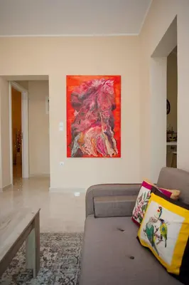 a living room with a couch and a painting on the wall at Skyway Comfort Residences in Spáta