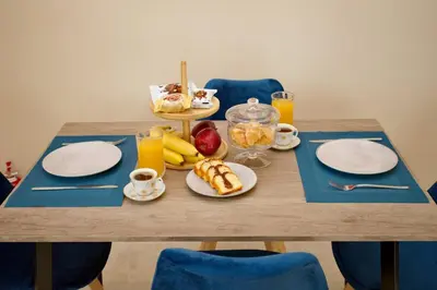 a table with plates of food and fruit on it at Skyway Comfort Residences in Spáta