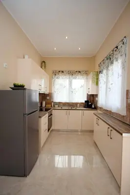 a kitchen with white cabinets and a stainless steel refrigerator at Skyway Comfort Residences in Spáta