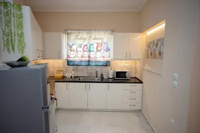 a kitchen with a sink and a refrigerator at Skyway Comfort Residences in Spáta