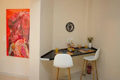 a room with a table and two chairs and a painting at Skyway Comfort Residences in Spáta