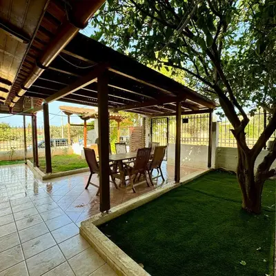 a pavilion with a table and chairs and a tree at Betty's House in Porto Rafti