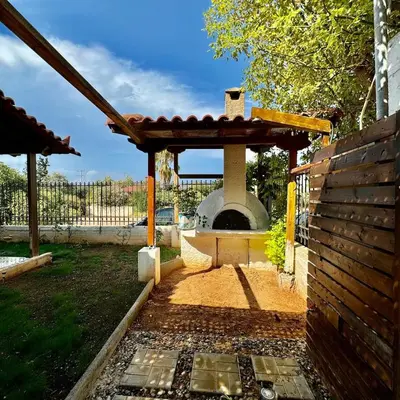 a patio with a pizza oven in a yard at Betty's House in Porto Rafti