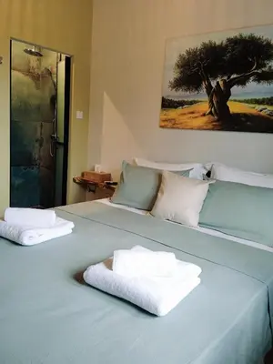 a blue bed with two towels on top of it at Olive apartment in Paianía