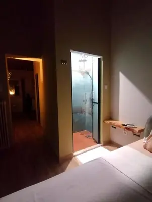 a bedroom with a glass door leading to a shower at Olive apartment in Paianía