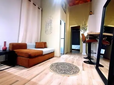 a living room with a couch and a piano at Olive apartment in Paianía